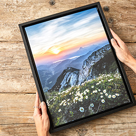 holding a framed painting